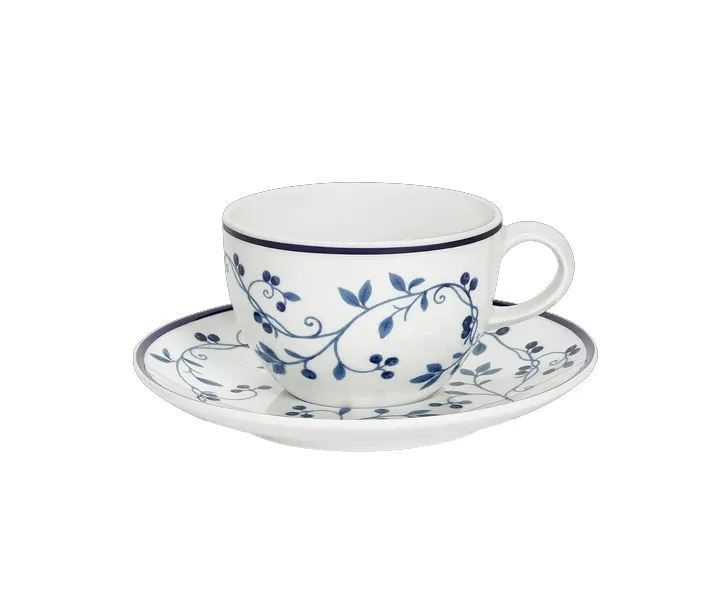 A white teacup and saucer decorated with a blue botanical vine pattern.