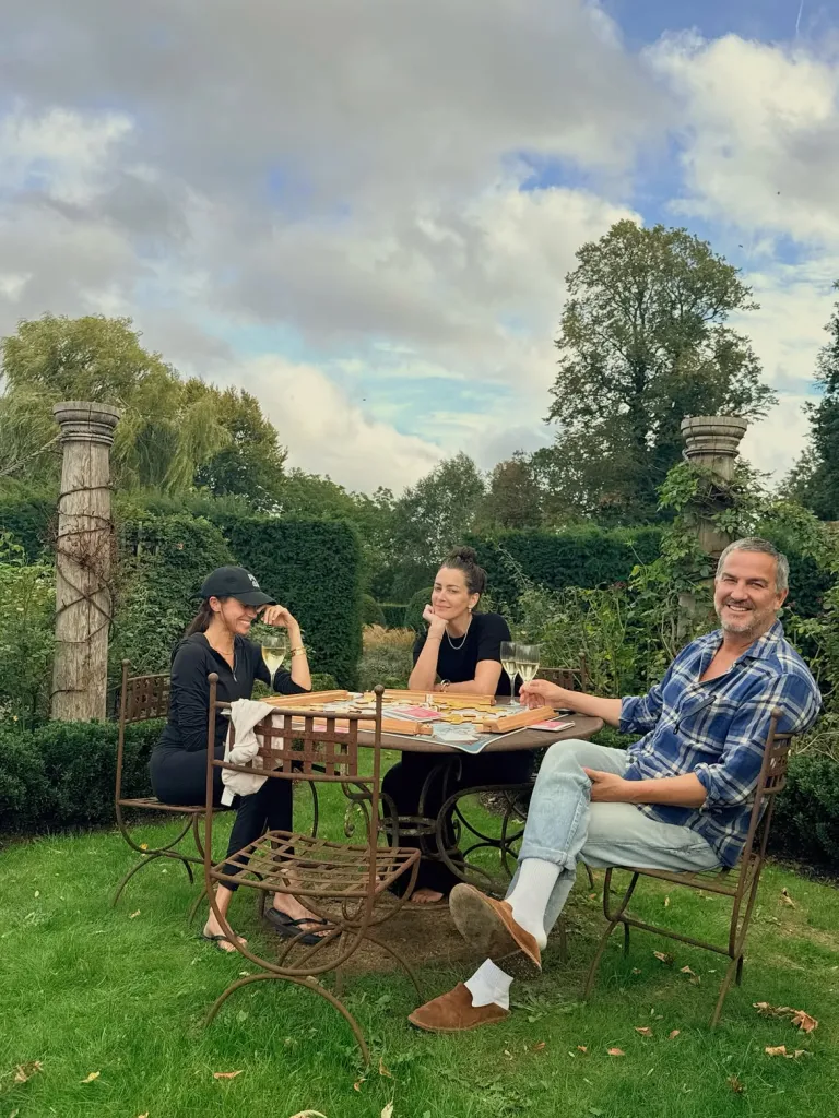 Meghan Markle, in a black baseball cap, and black top and pants, Kelly McKee Zajfen, in a black top and black pants, and Markus Anderson, in a blue checked shirt and blue jeans.