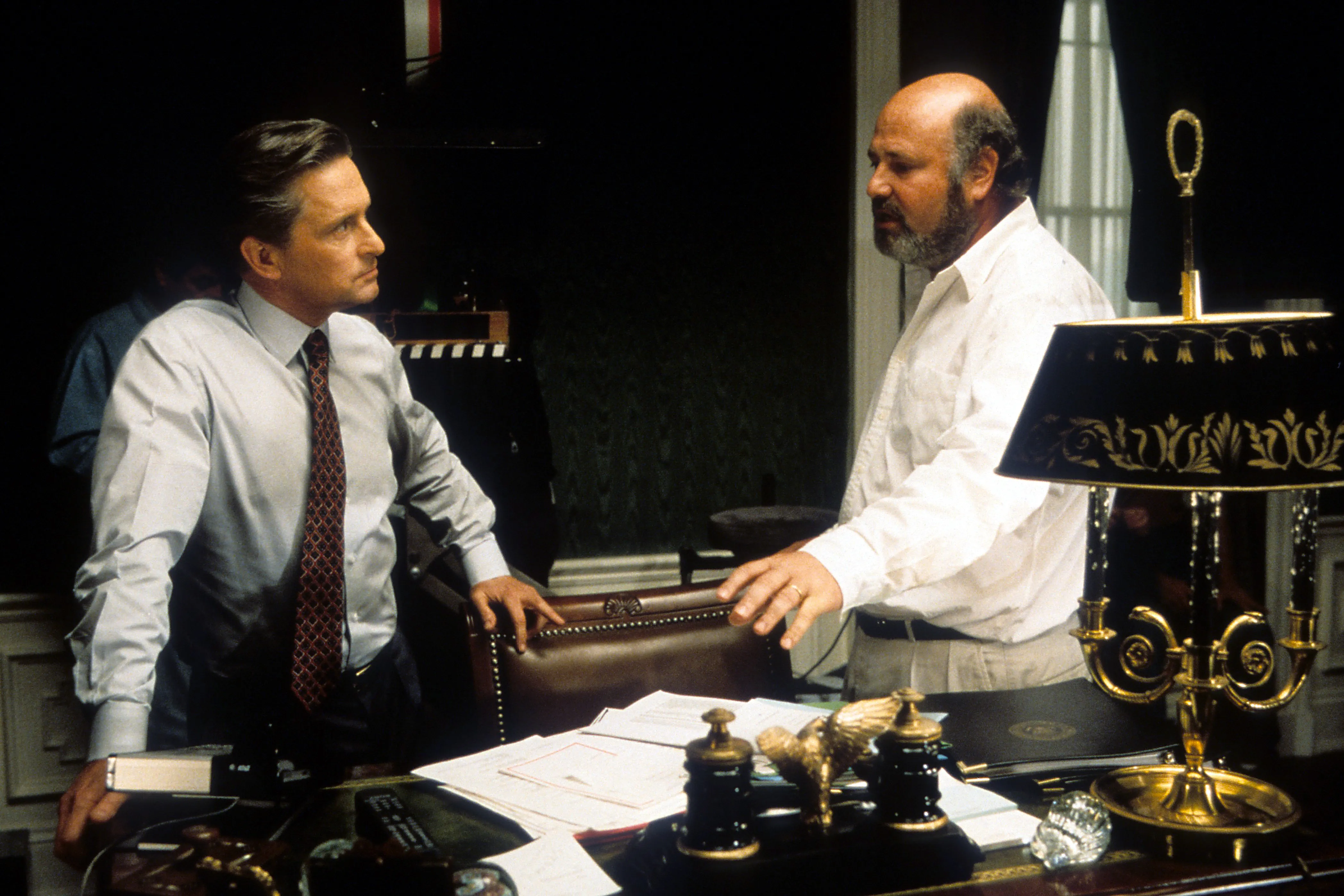 Michael Douglas listening to director Rob Reiner on the set of 'The American President'.