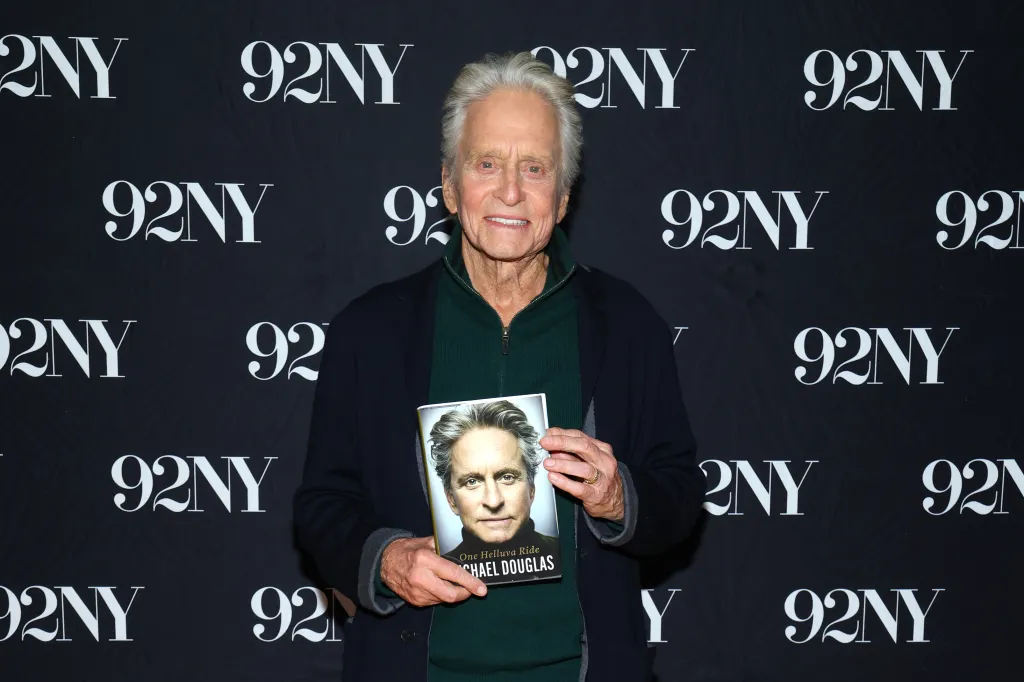 Michael Douglas holding a copy of his book, 