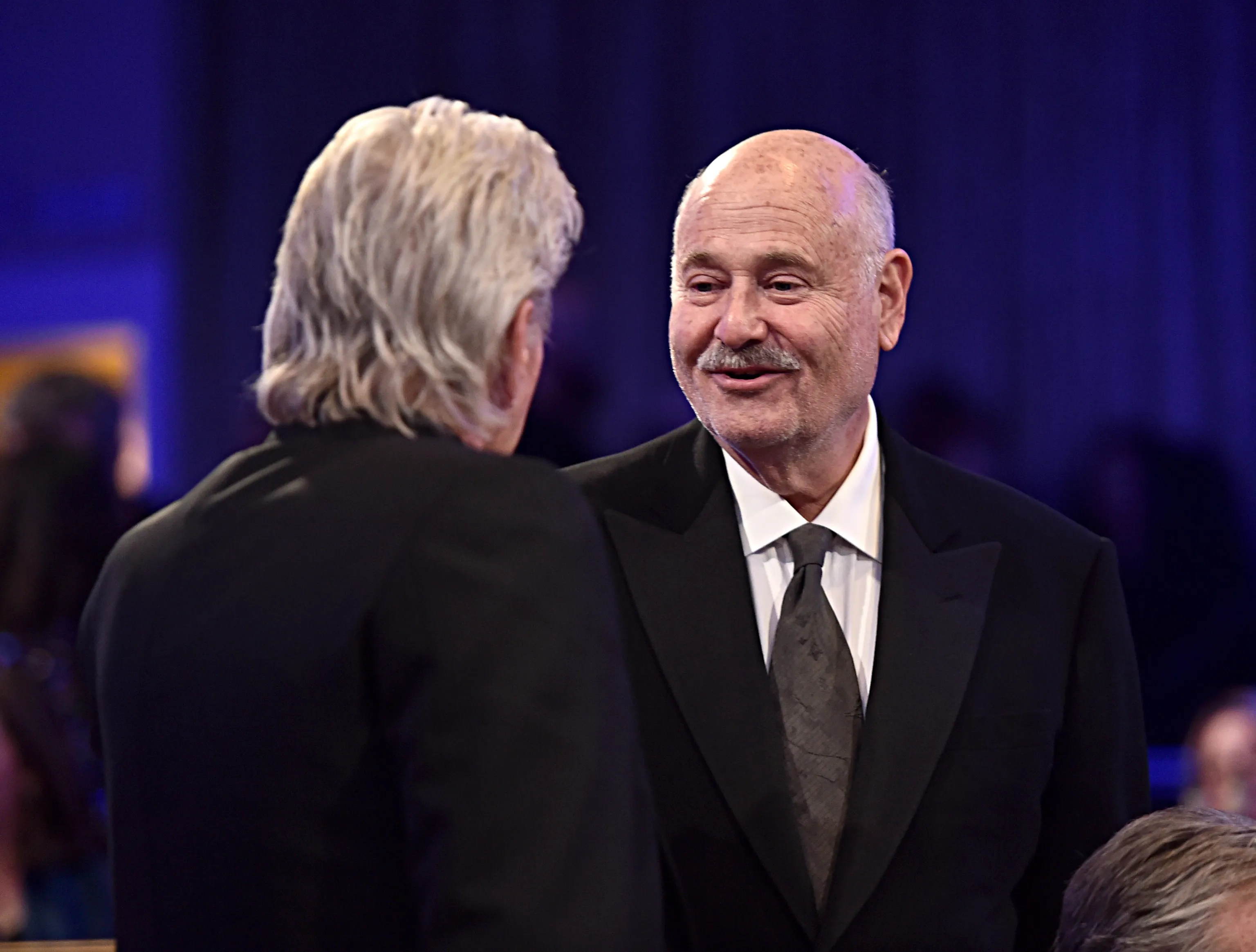 Rob Reiner and Michael Douglas talking at an event.