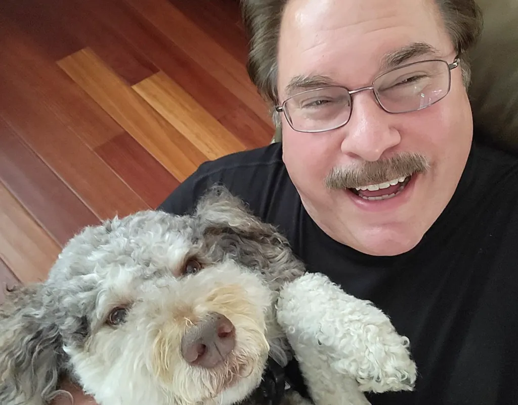 Mike Horn smiling and holding a fluffy dog.