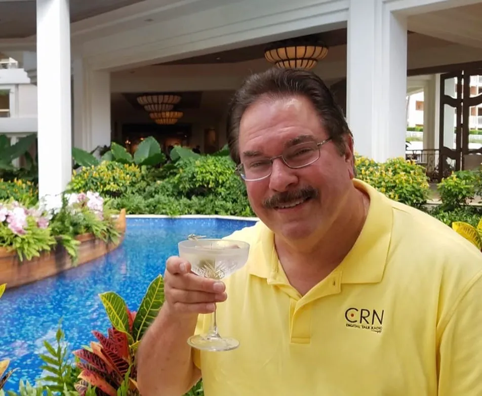 Mike Horn holding a cocktail in front of a pool.