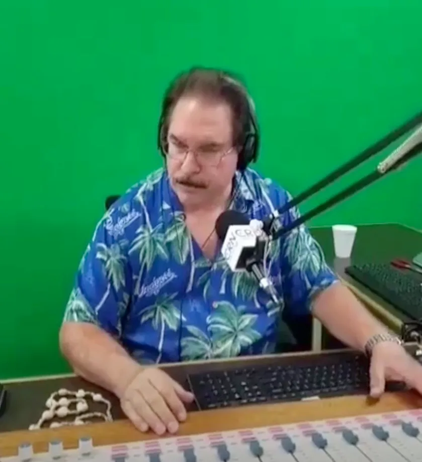 Mike Horn wearing a blue Hawaiian shirt in a radio studio.