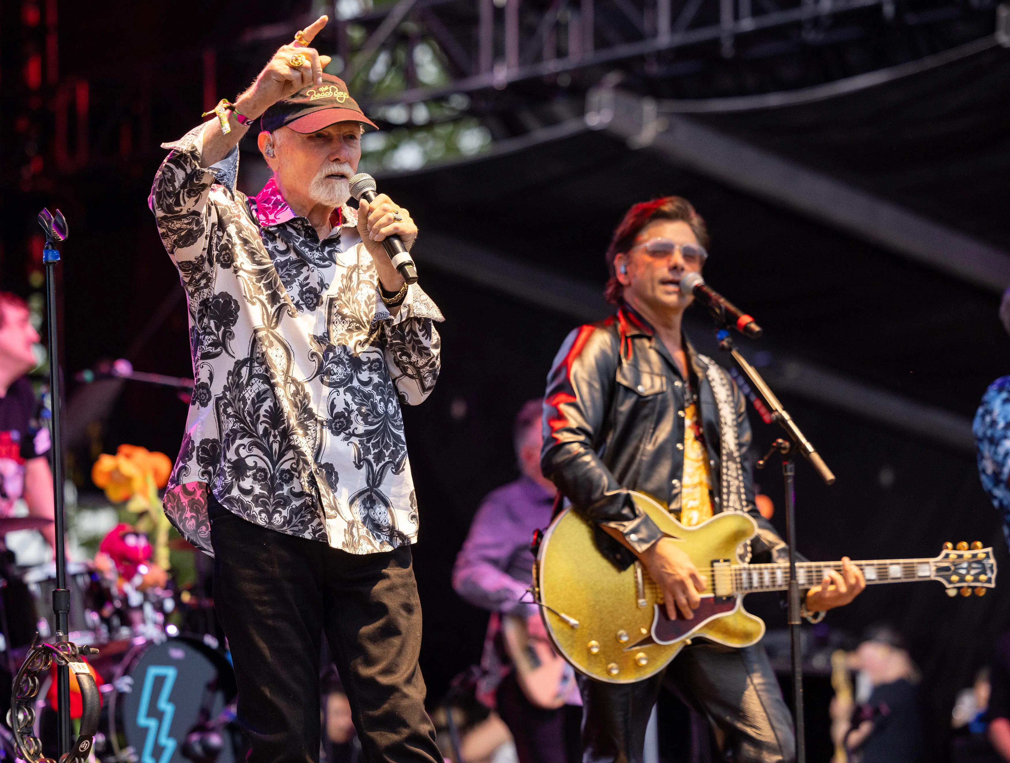 Mike Love and John Stamos of The Beach Boys perform on stage.