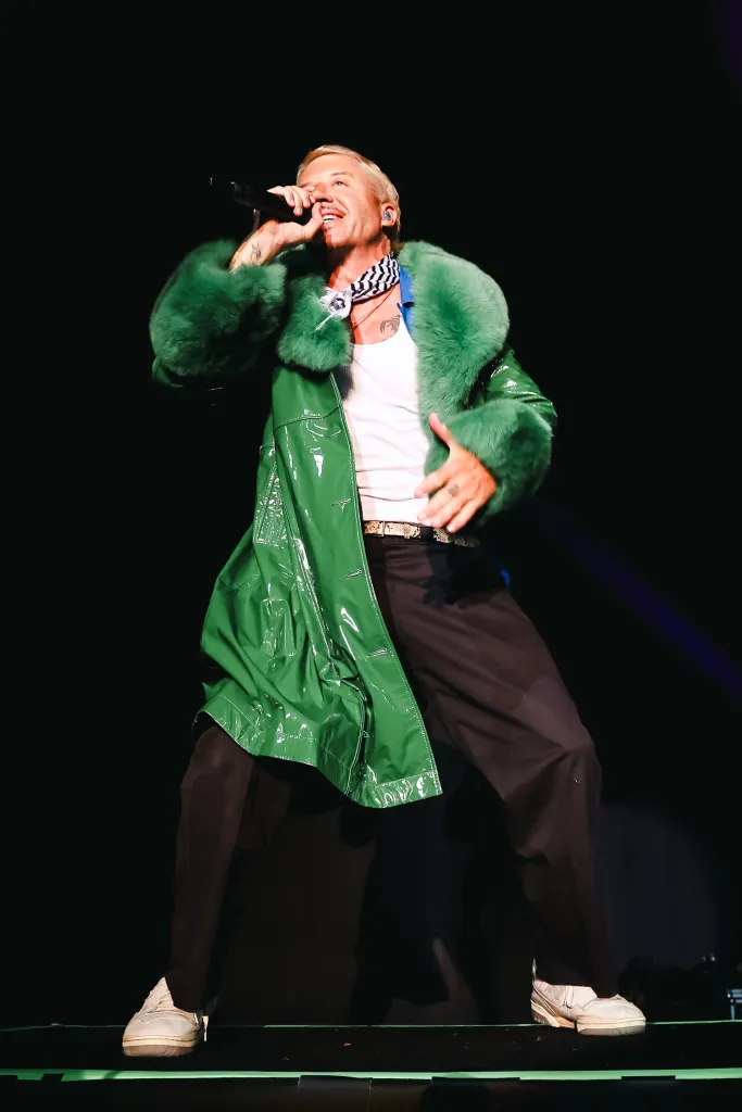 Macklemore performs in concert in Milan wearing a green fur-trimmed coat.