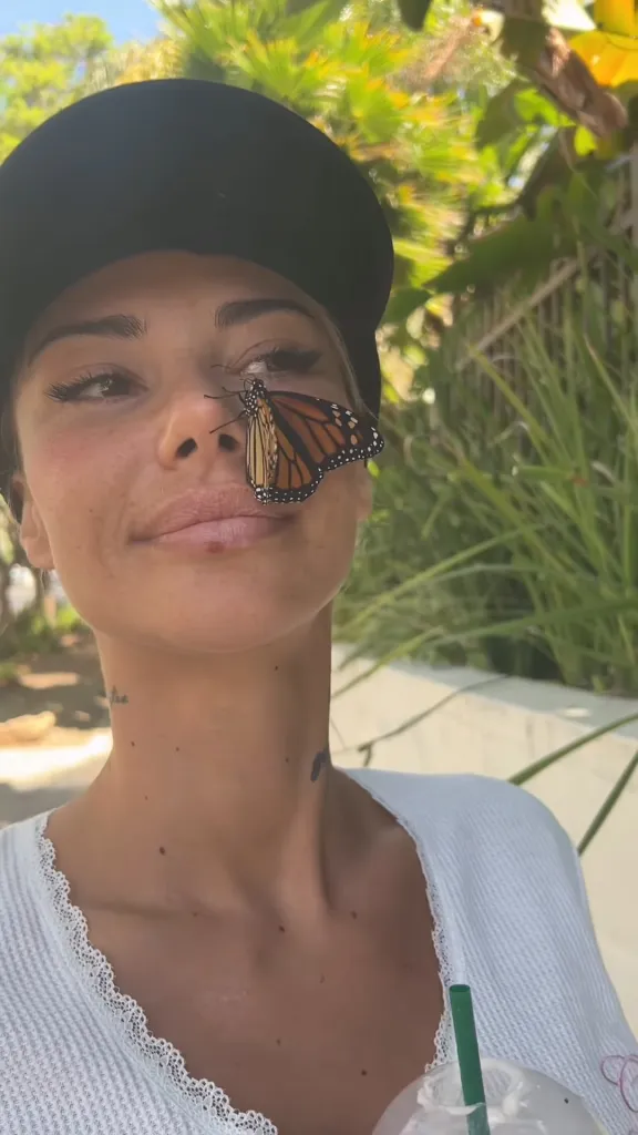 Sahara Ray with a monarch butterfly on her nose.