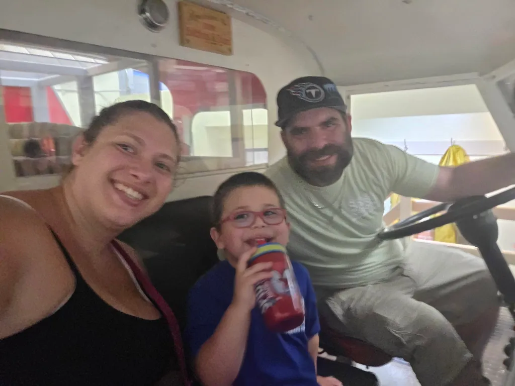 Metallica Rose Harrison, Charles Harrison, and their son pose for a selfie together inside a vehicle.