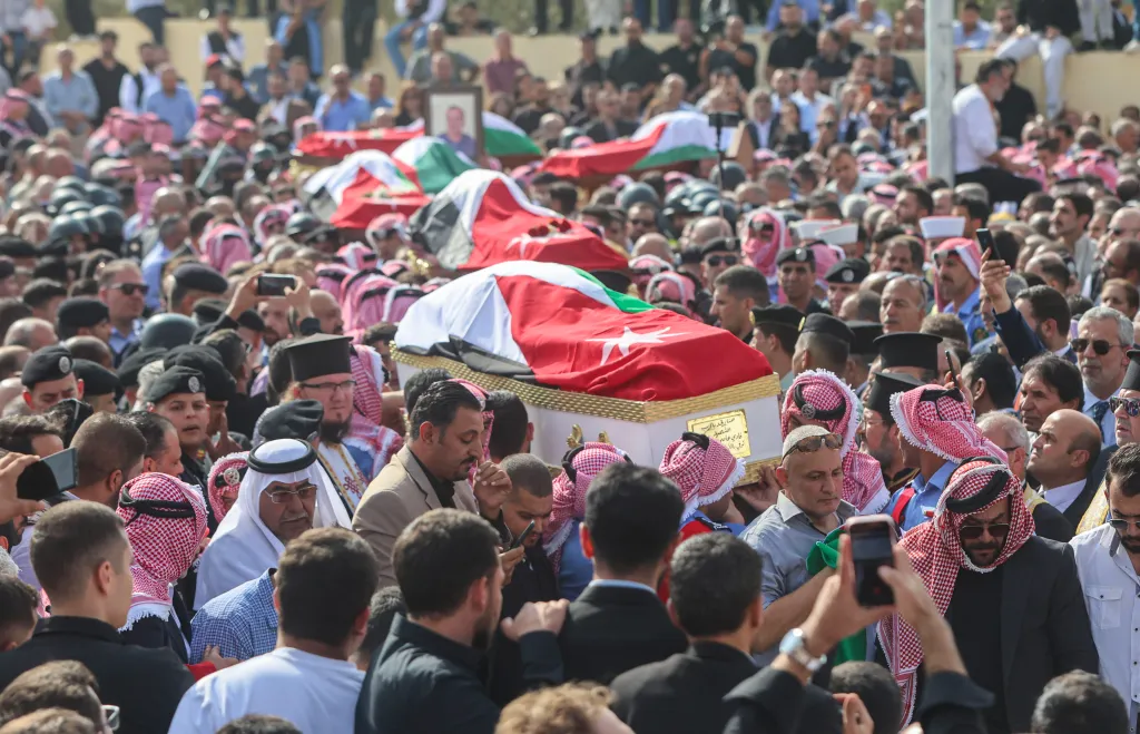 Mourners carry caskets draped in Jordanian flags during a funeral service in Al-Karak.