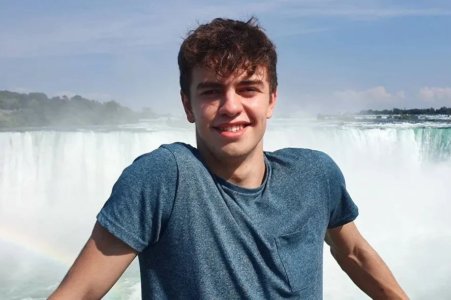 William Chapman smiling in front of a waterfall.