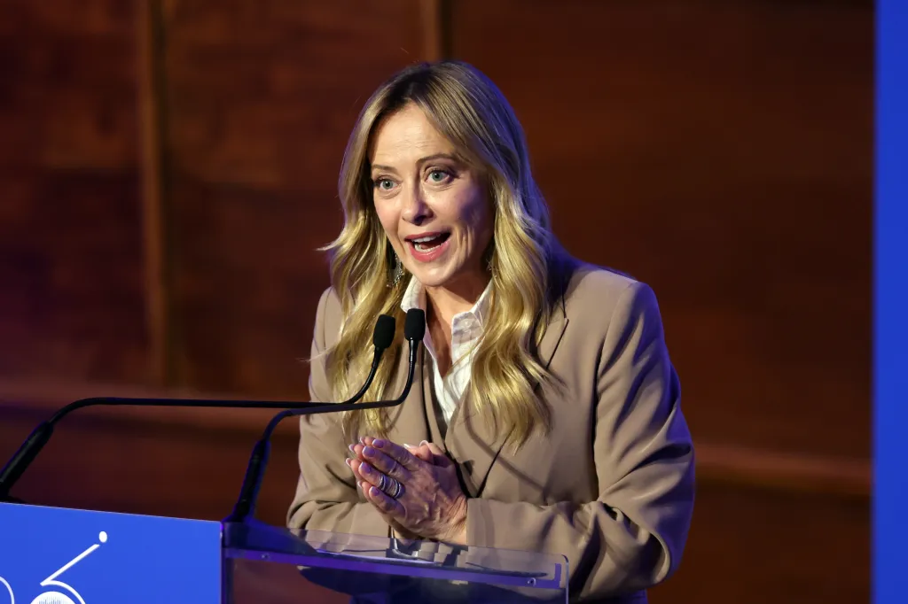 Italian Prime Minister Giorgia Meloni giving a speech at a podium.