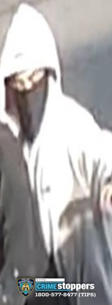 Surveillance camera still of a person wearing a white hooded sweatshirt and face covering, wanted by the NYPD for a robbery pattern.
