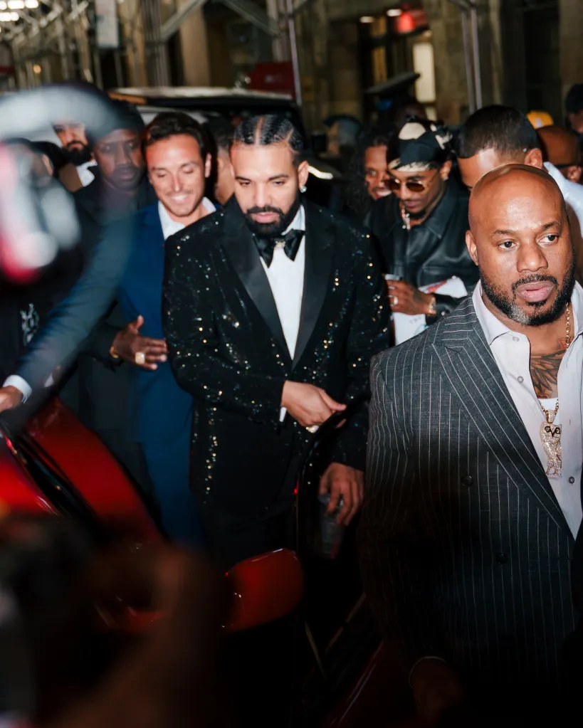 Drake surrounded by people in New York City.