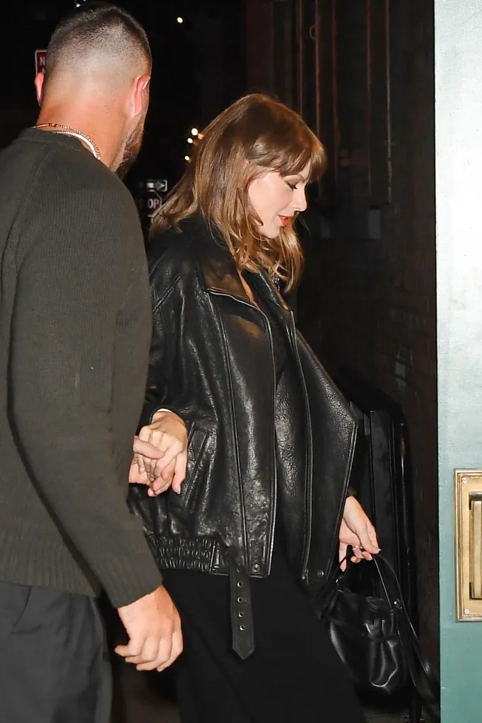 Taylor Swift and Travis Kelce hold hands as they arrive at a restaurant.