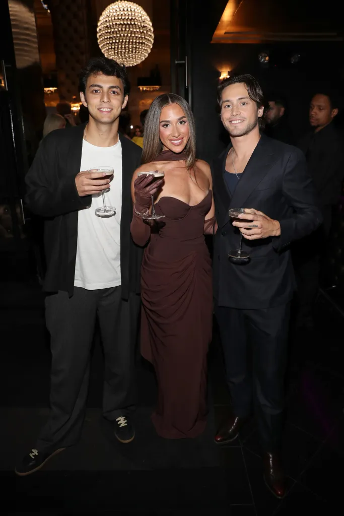Shai Fruchter, Ariana Biermann, and Liam Obergfoll pose together, each holding a cocktail glass, at the Virtual Reali-Tea Awards.