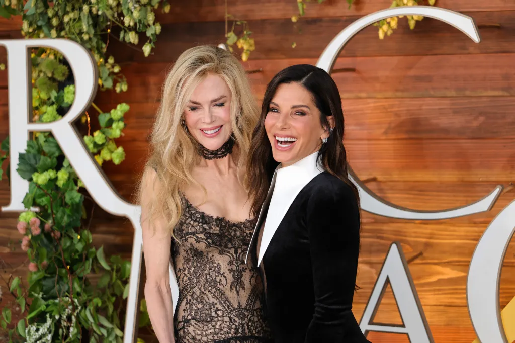 Nicole Kidman, in a black lace gown, and Sandra Bullock, in a black jacket with white collar, attend the U.S. Premiere of 
