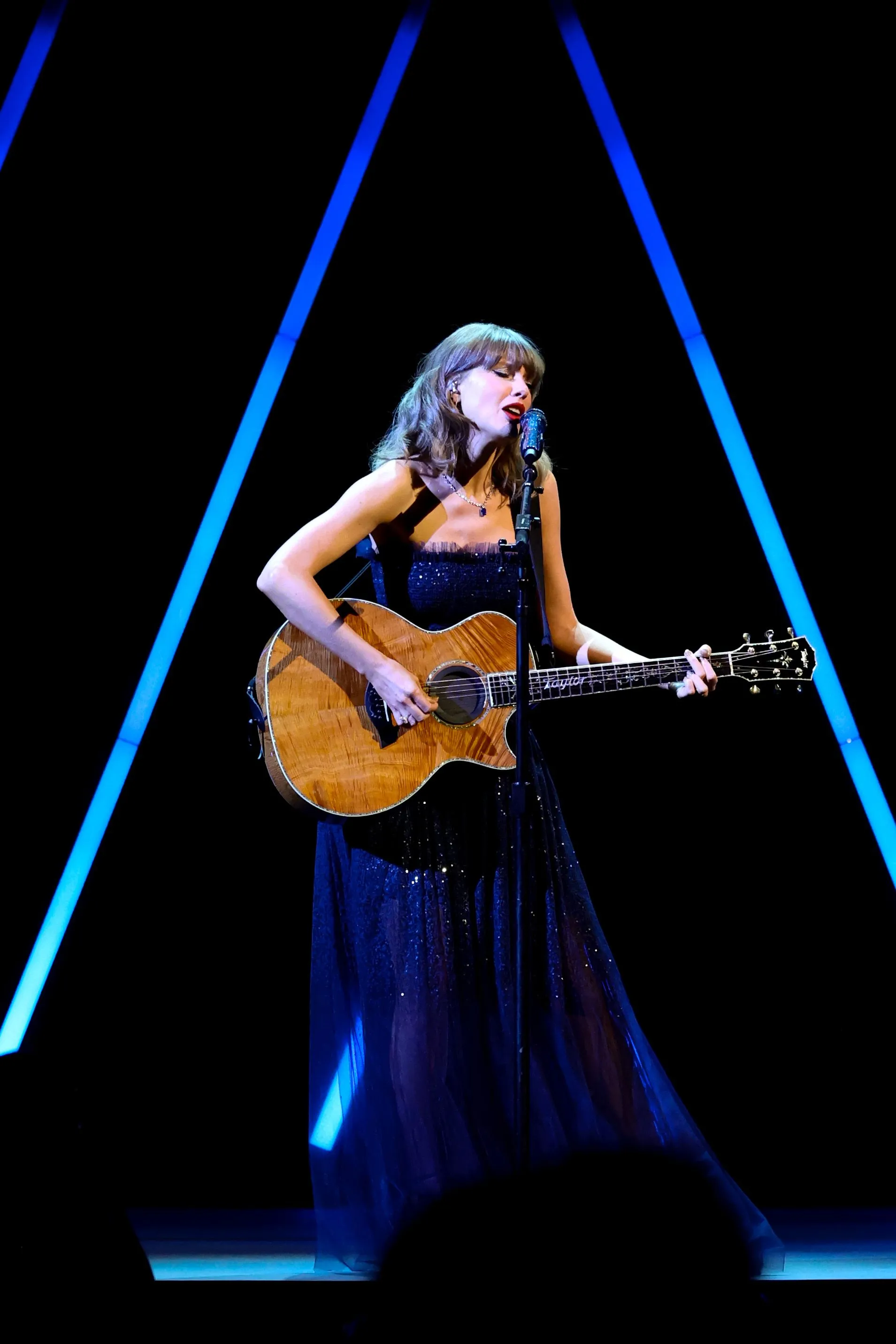 Taylor Swift performs onstage while playing an acoustic guitar during the Academy Museum Gala.