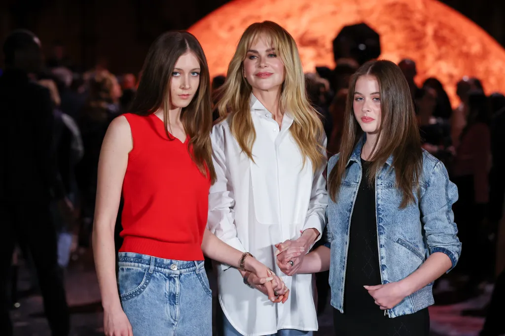Sunday Rose Kidman Urban, in a red tank top and blue jeans, Nicole Kidman, in a white shirt, and Faith Margaret Kidman-Urban in a blue denim jacket and black top, at the Chanel show during Paris Fashion Week.
