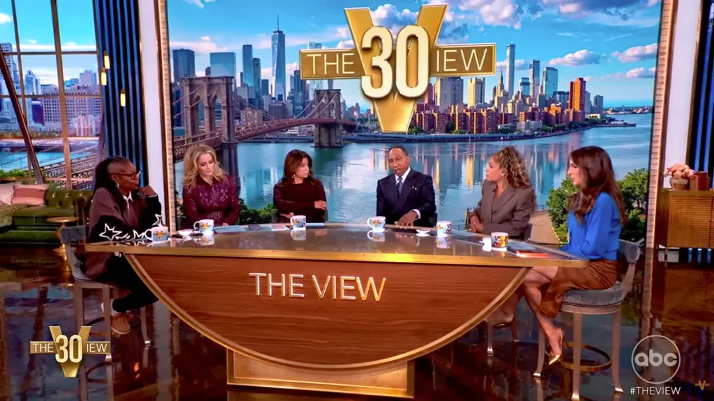 Stephen A. Smith and the co-hosts of The View seated at the show's desk.