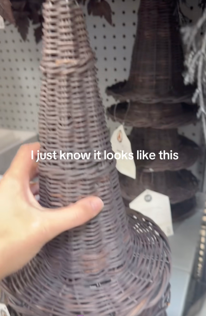 A person holding a tall, pointed wicker decoration in a store, with the overlaid text 