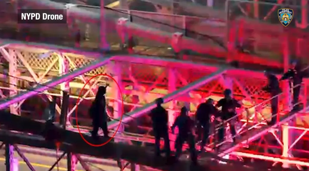 NYPD drone footage shows police officers confronting a knife-wielding man on the Brooklyn Bridge.