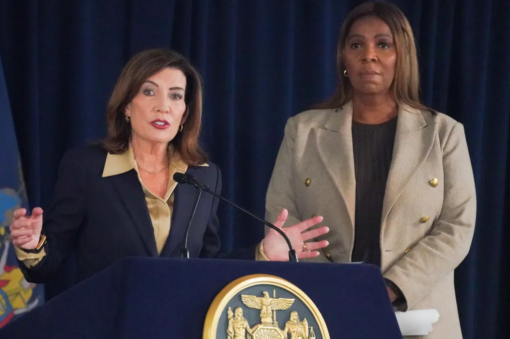 New York Governor Kathy Hochul speaks at a podium with New York State Attorney General Letitia James standing behind her.