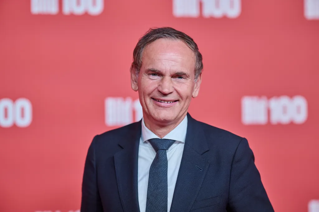 Oliver Blume, CEO of Volkswagen, stands on the red carpet at Axel Springer's BILD100 event.