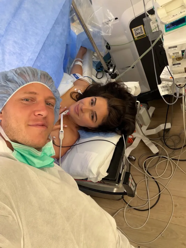 Christian McCaffrey taking a selfie with Olivia Culpo in a hospital delivery room.