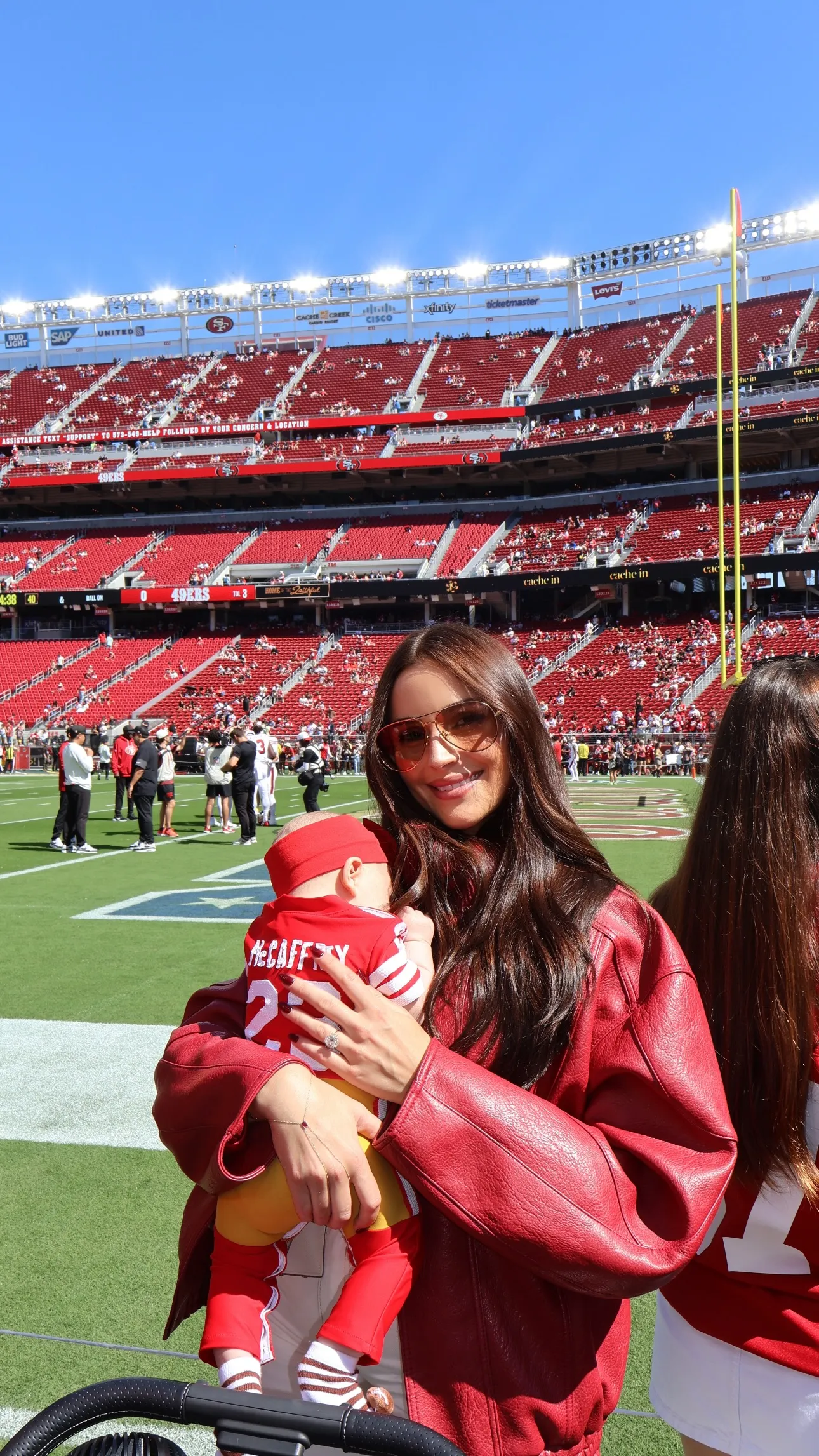 Olivia Culpo holding her baby, both wearing red