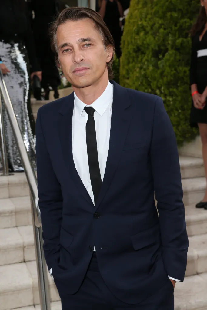 Olivier Martinez wearing a dark suit and tie at an event.