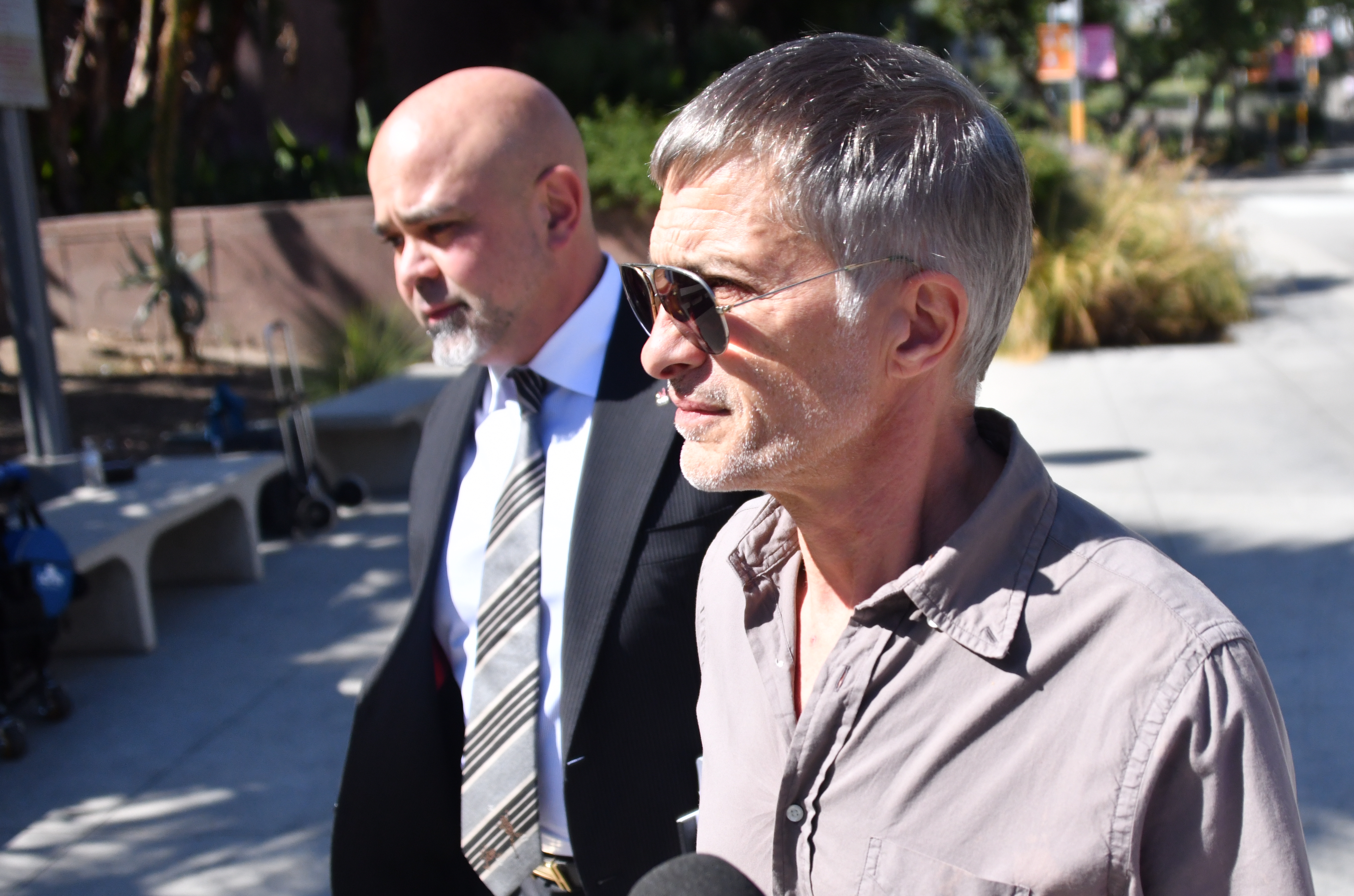 Olivier Martinez and his lawyer walking together outdoors.