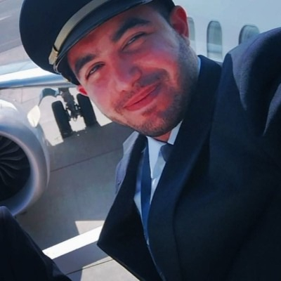 Hamam Al Hammami in pilot uniform in front of an aircraft.