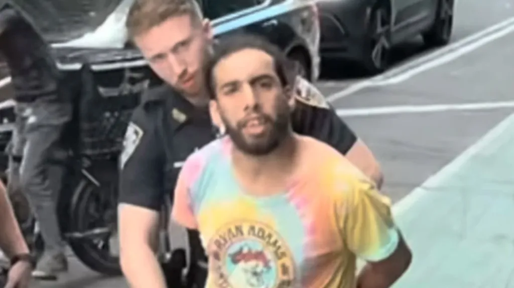 A police officer arresting a suspect involved in the theft of an Orthodox Jewish man's hat in Midtown Manhattan.