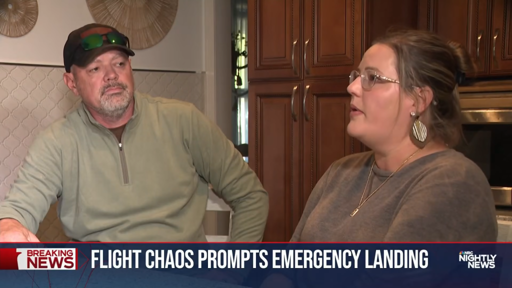 A man and a woman being interviewed in a kitchen.