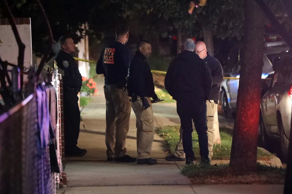 Police officers investigate a shooting scene in Ozone Park, Queens.