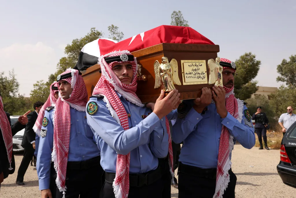 Pallbearers carry a coffin draped in a flag during a funeral in Karak, Jordan.
