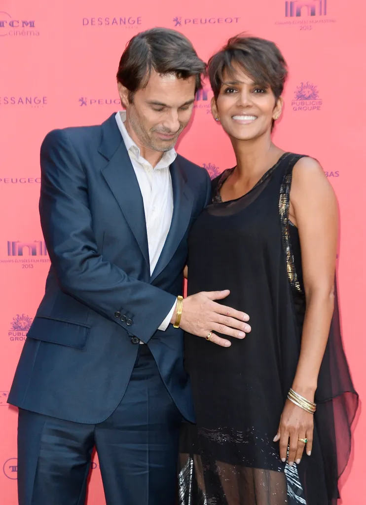 Halle Berry, in a black sleeveless dress, and Olivier Martinez, in a blue suit.