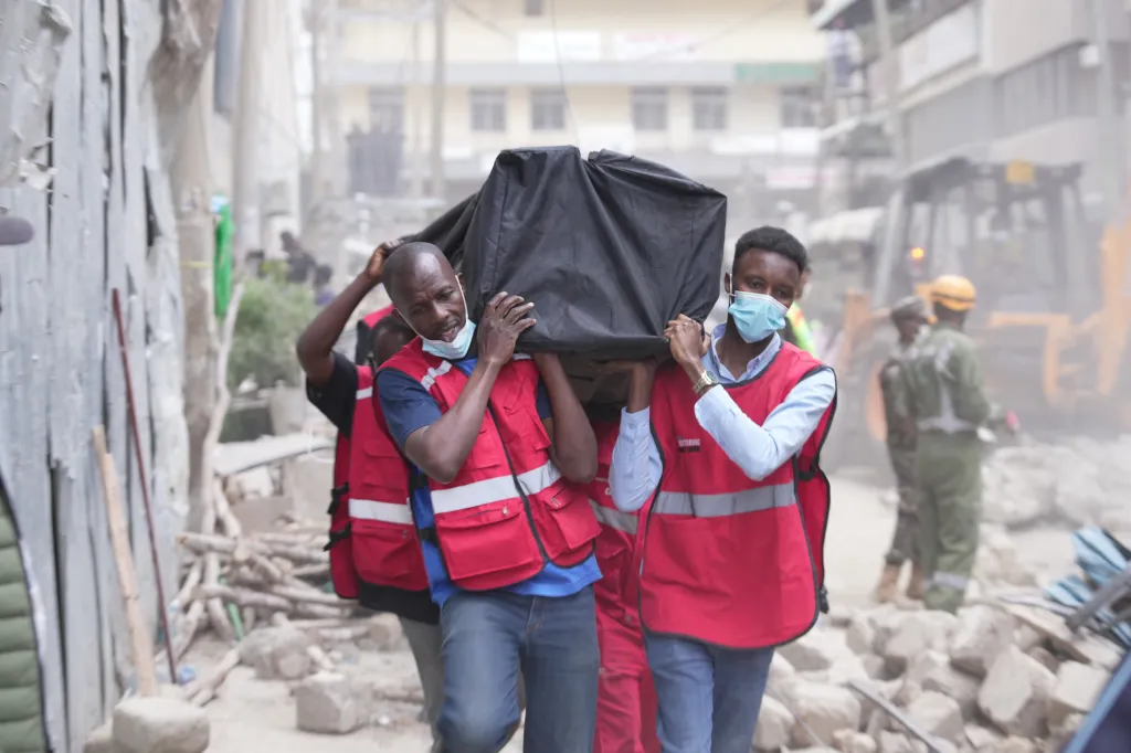 People carry rescue equipment at the scene of a collapsed building in Nairobi, Kenya.