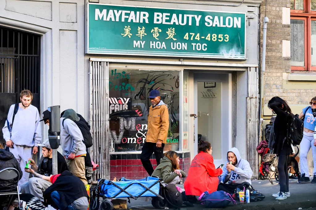 People congregate on a sidewalk in the Tenderloin neighborhood of San Francisco.