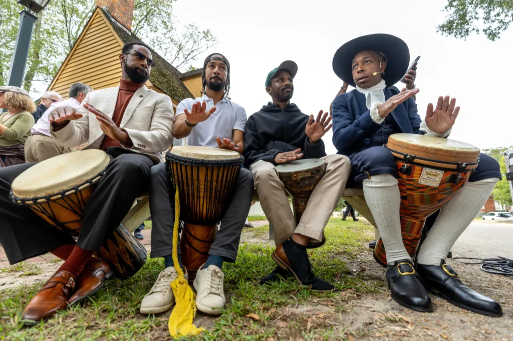 Four men drum during a community-wide rededication ceremony of the reconstructed African Baptist Meeting House.