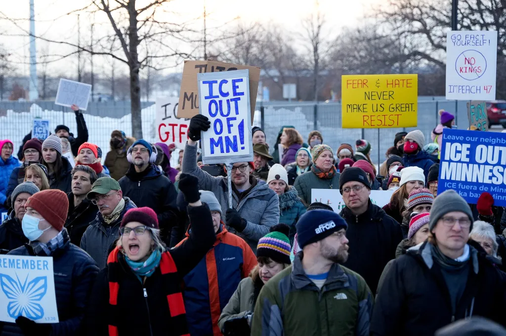 People holding protest signs outside the Whipple Building in Minneapolis.