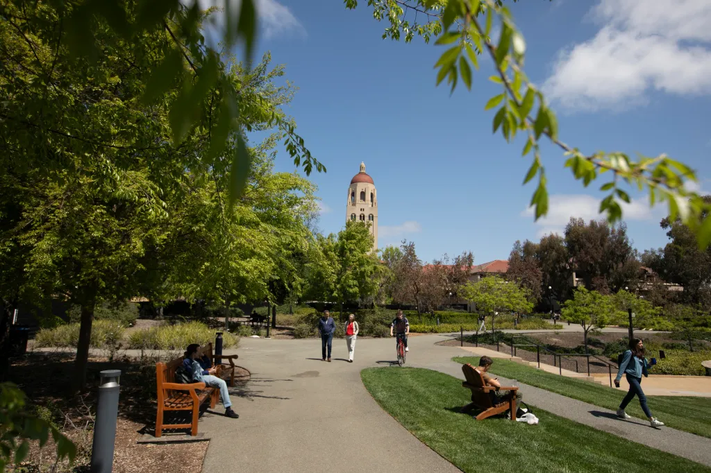 People walking on the campus of Stanford University in Palo Alto, California, with Hoover Tower in the background.