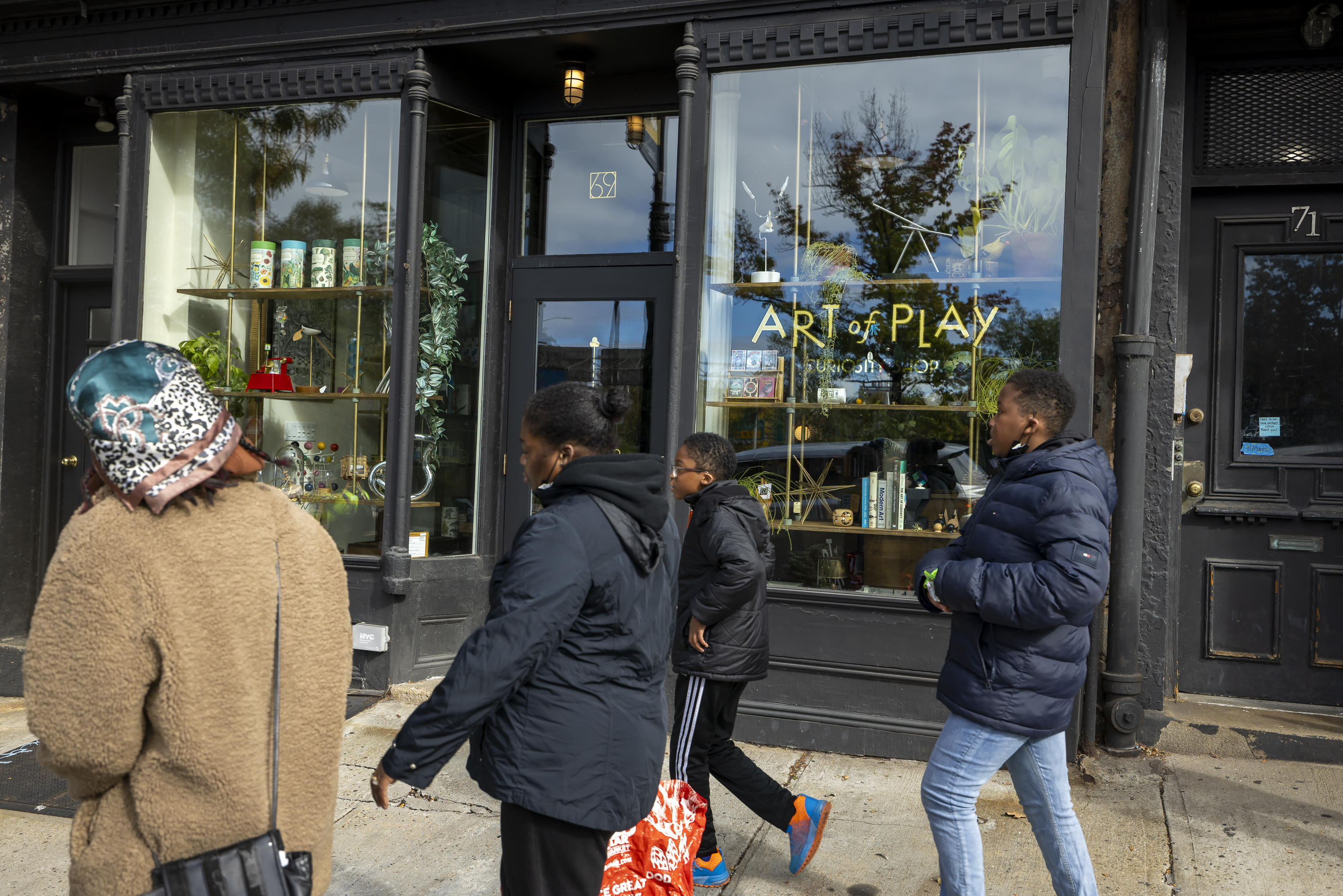 People walk past the Art of Play toy store in Brooklyn, New York.