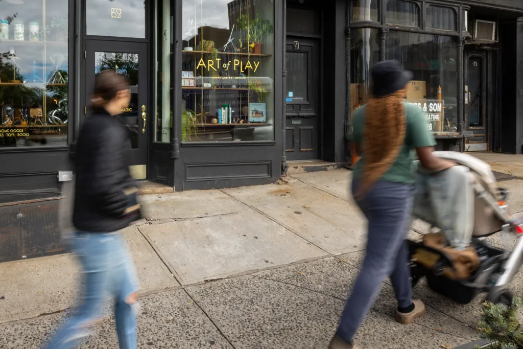 People walk past the Art of Play toy store in Brooklyn.