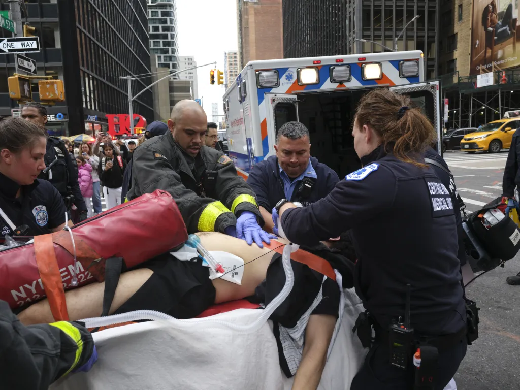 Emergency responders provide medical care to a shooting victim outside a Midtown subway station.