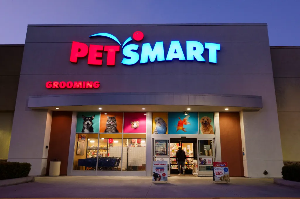 PetSmart store exterior with an illuminated sign and animal pictures on the windows.