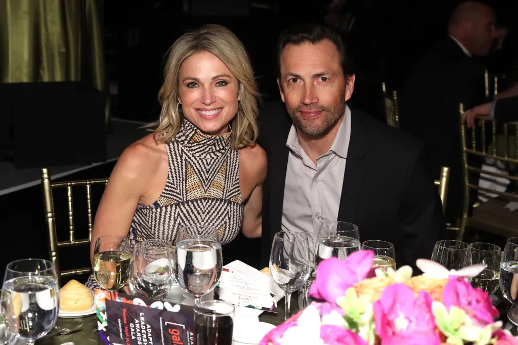 Amy Robach and Andrew Shue seated at a table at the ADAPT Leadership Awards.