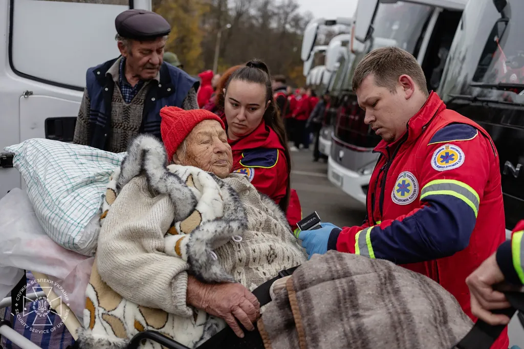 Ukrainian medics assist an elderly resident evacuated from the city of Oleshky during a humanitarian mission.