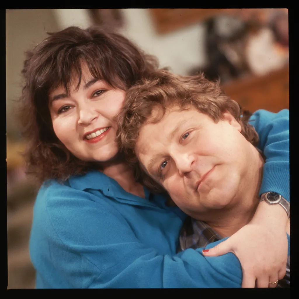 Roseanne Barr and John Goodman posing together.