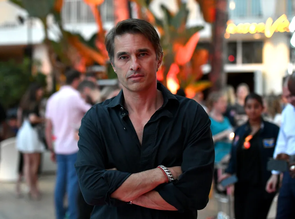 Olivier Martinez stands with his arms crossed at an event.
